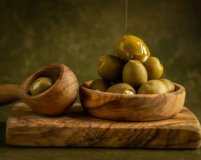 a wooden spoon with a group of potatoes on it