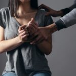 woman in gray scoop neck shirt holding her hands