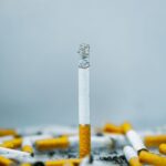 A close-up image of cigarette butts scattered on a white surface, highlighting tobacco addiction.