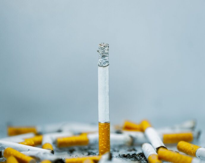 A close-up image of cigarette butts scattered on a white surface, highlighting tobacco addiction.
