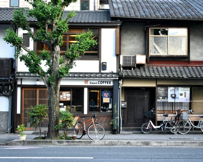 A coffee shop with a ginkgo tree and bicycles on a Japanese street