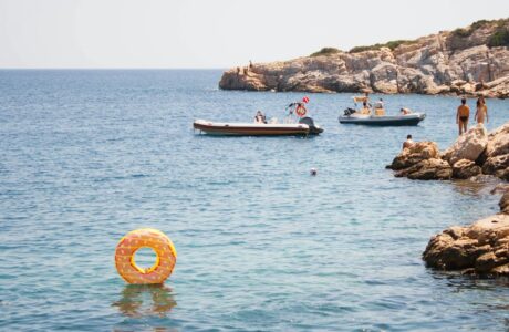 group of people swimming on body of water during daytime