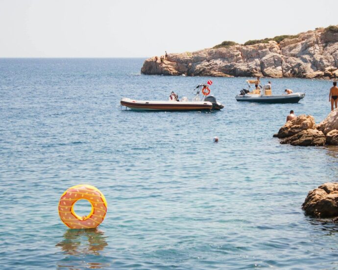 group of people swimming on body of water during daytime