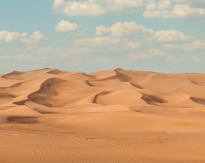 a large group of sand dunes under a blue sky