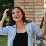 A young woman laughing with her hands in her hair