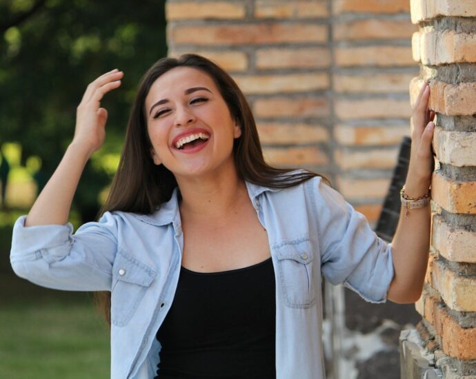 A young woman laughing with her hands in her hair