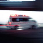 an ambulance is driving down the street with its lights on