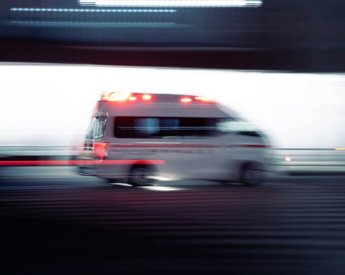 an ambulance is driving down the street with its lights on