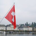 red and white flag on pole near body of water during daytime