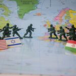 Toy soldiers face off on world map with flags