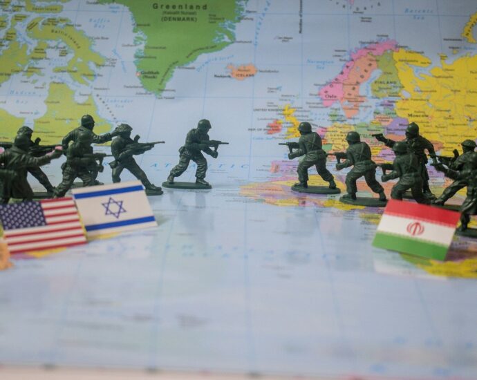 Toy soldiers face off on world map with flags