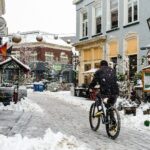 A person rides a bicycle on a snowy street