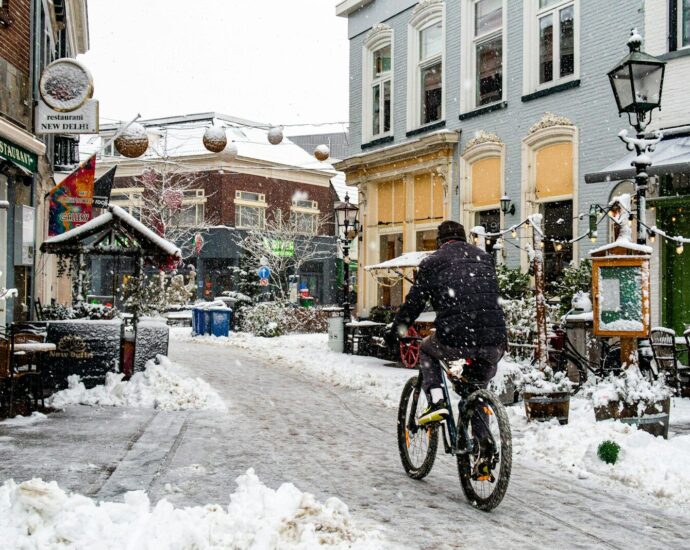 A person rides a bicycle on a snowy street