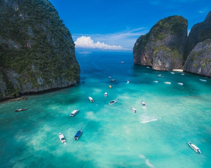 Boats on the turquoise water of Maya Bay between limestone cliffs in Thailand
