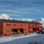 Orange buildings in a snowy arctic landscape