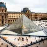 a large glass pyramid in front of a building