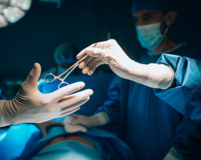 a person in a surgical gown is holding a pair of scissors