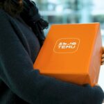 Woman holding an orange temu package