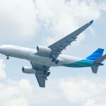 white and blue airplane under white clouds during daytime