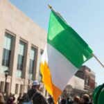 a group of people walking down a street holding flags