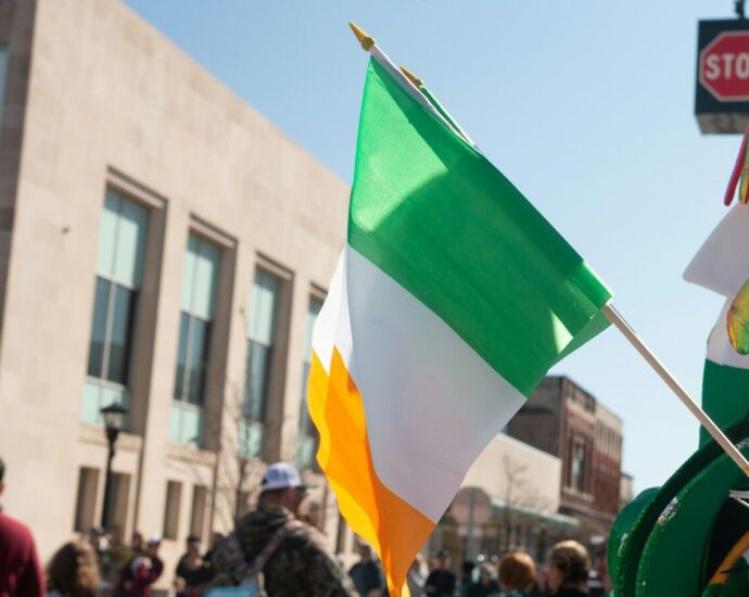 a group of people walking down a street holding flags